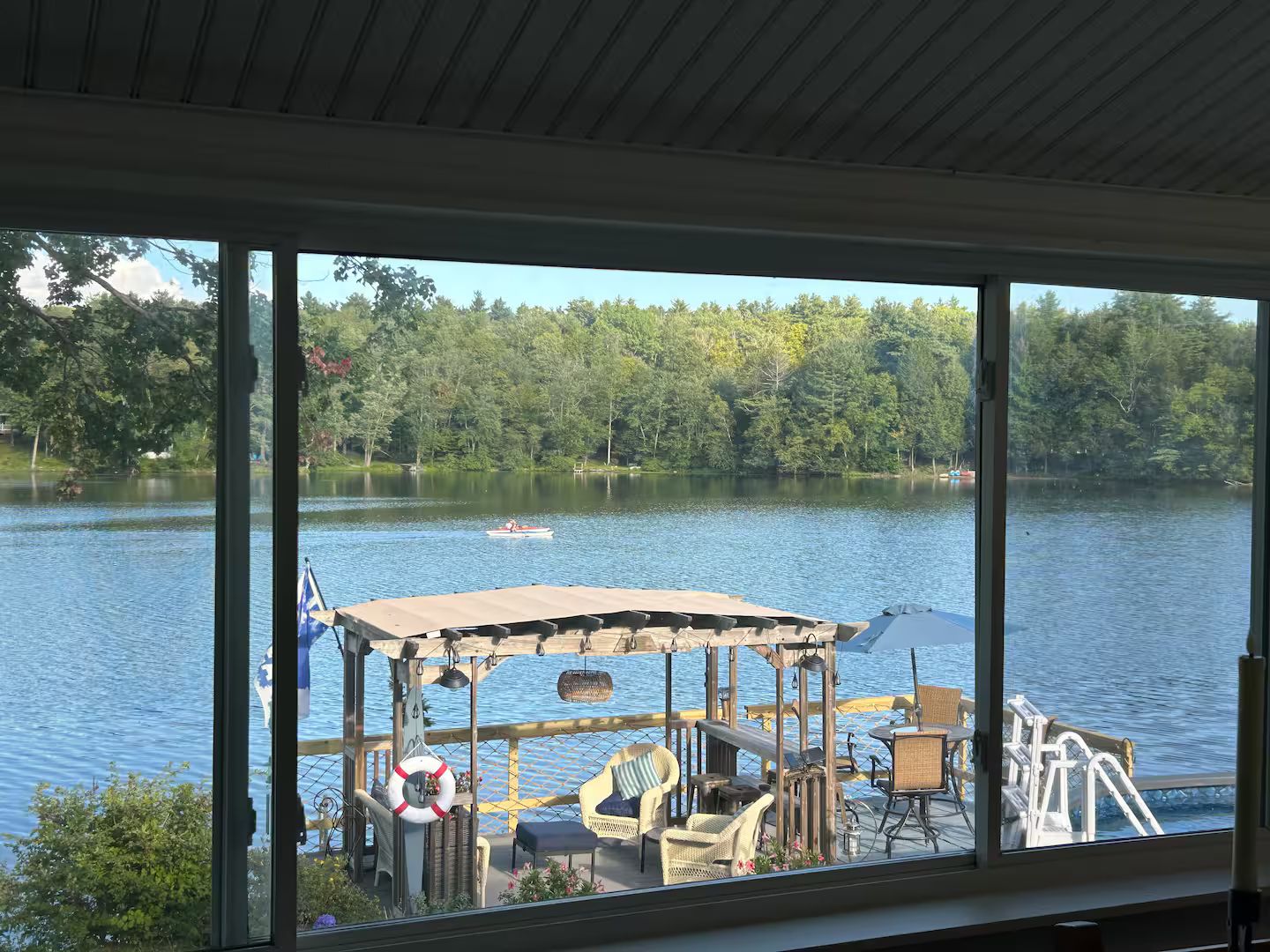 A lakeside deck with outdoor seating and a view of a lake.