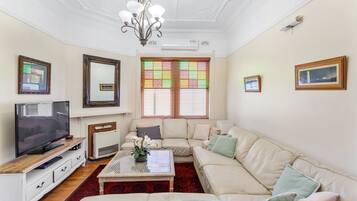 A living room with a television, sofa, coffee table, and decorative items.