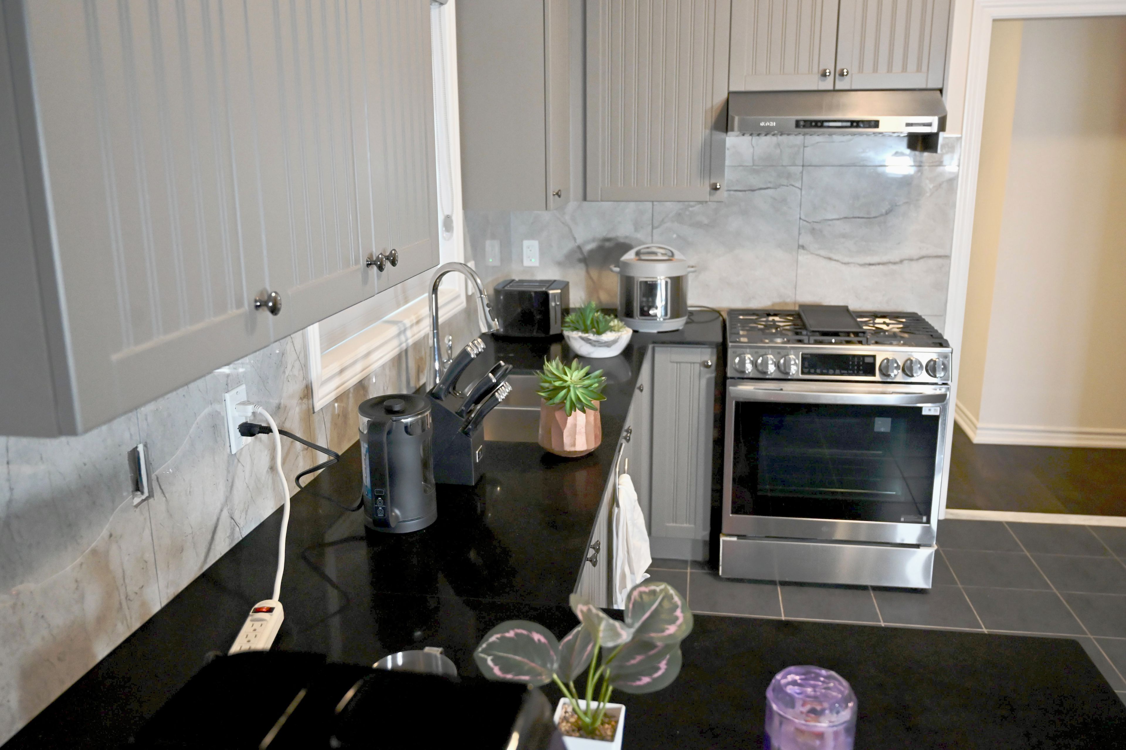 A kitchen with a stove, oven, and countertop appliances.