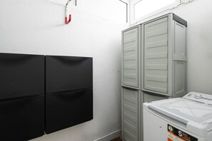 A laundry room with stacked cabinets and a washing machine. - Maspalomas Bungalow: Private Terrace, Pool, BBQ, and A/C (San Bartolomé de Tirajana)