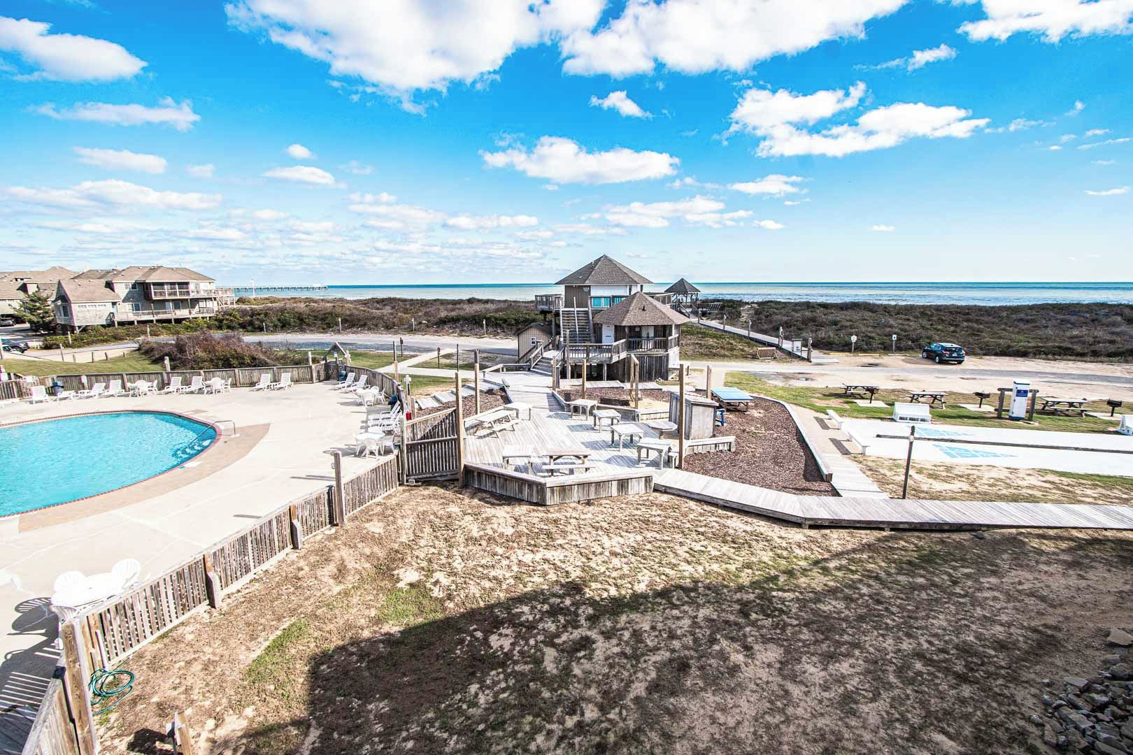A resort with a swimming pool, beach access, and a lifeguard tower.