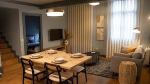 Una sala de estar moderna con comedor, una escalera y un sofá.