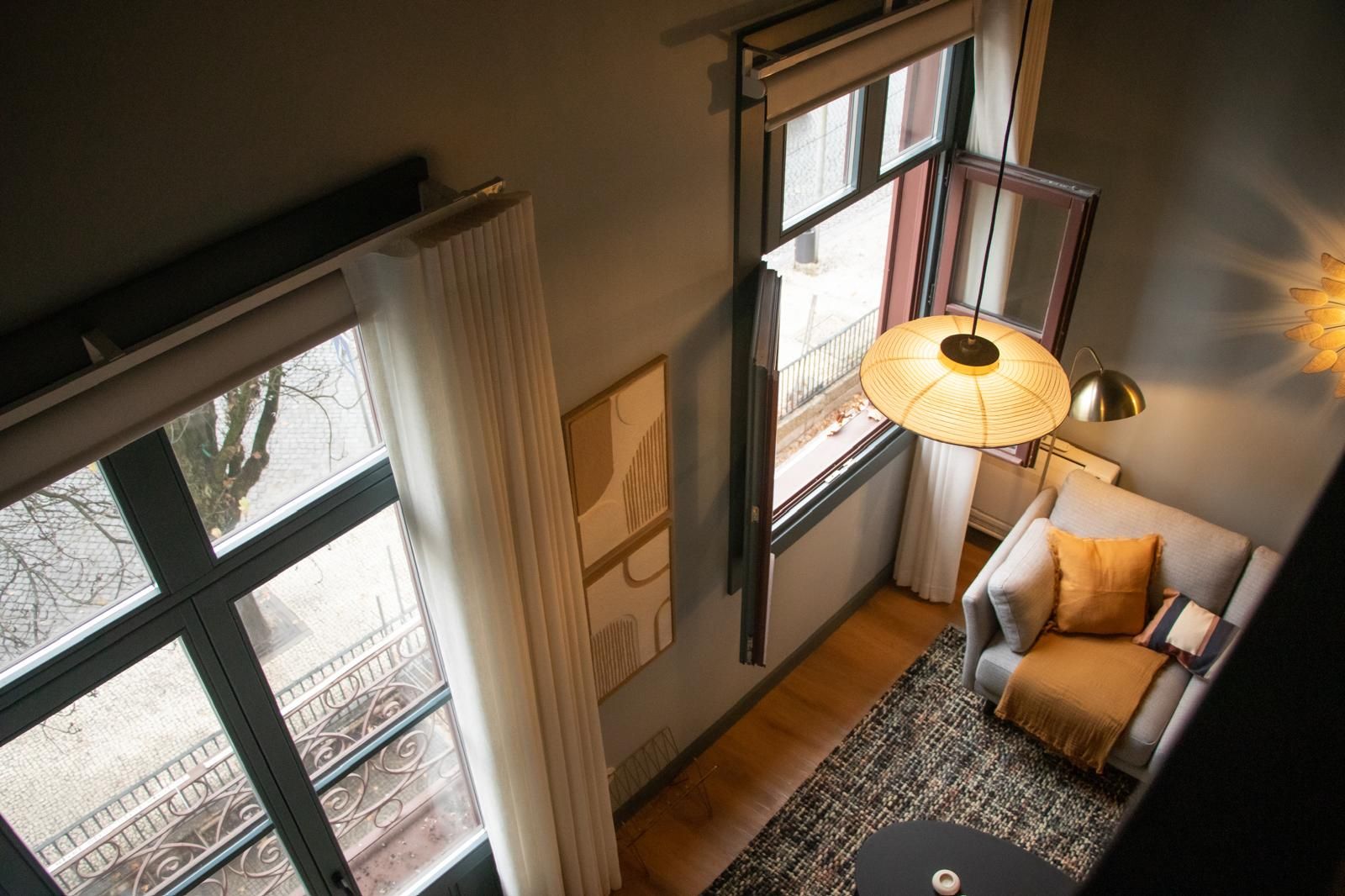 Une pièce avec un canapé, une lampe et une vue par la fenêtre.