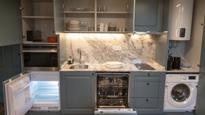 Cocina compacta con lavavajillas integrado, un lavabo y lavadora.