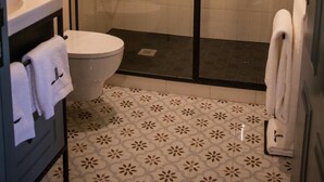 Un baño moderno con ducha envuelta en vidrio, inodoro y lavabo.