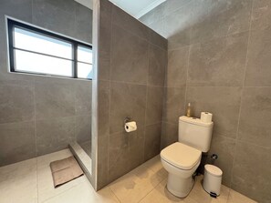 Ein modernes Badezimmer mit Toilette, Bidet und einer kleinen Mülltonne.