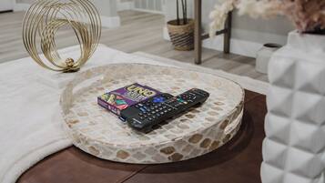 A round, stone-patterned tray with a remote control and a UNO game box on a white rug.