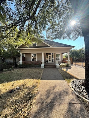 A two-story house with a covered porch and a gravel driveway. - Casa 746 Fort Worth Downtown Stockyards Retreat (Fort Worth)