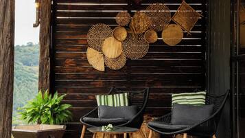 A cozy seating area with wicker furniture and a wall adorned with woven baskets.