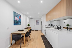 Eine moderne Küche mit weißen Schränken, einem Holzespeisetisch und Stühlen.