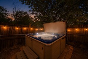 A hot tub with a wooden deck and a wooden fence in the background. - Hot Tub + Fire Pit + Movie Projector+ BBQ - Near DT Denver (Thornton)