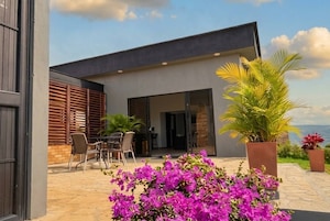 Un edificio moderno con un patio, mobiliario exterior y vistas al paisaje.