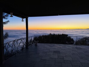 A terrace with a view of clouds and a sunset.