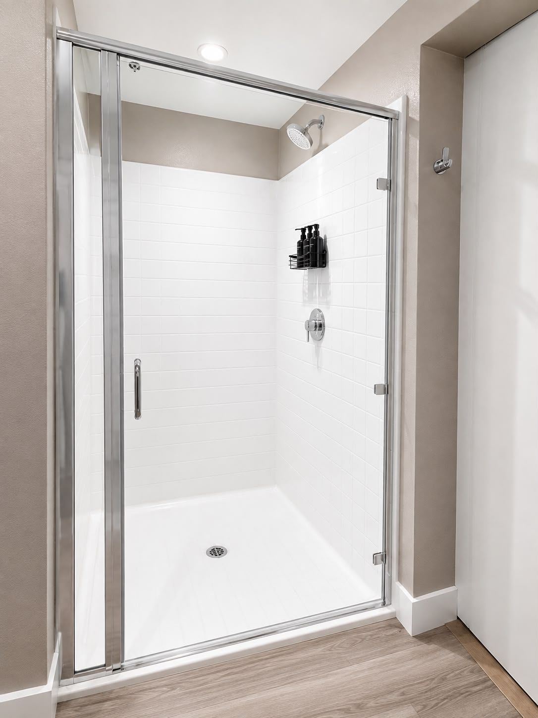 A modern shower enclosure with a glass door, a built-in showerhead, and a wall-mounted soap dispenser.