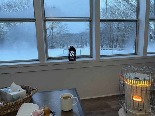 A cozy room with a table, a cup, a basket, and a heater.