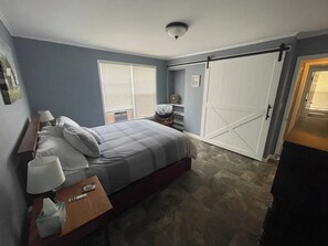 Ein Schlafzimmer mit Bett, Nachttisch, Lampe und einem Schiebetürenschrank.