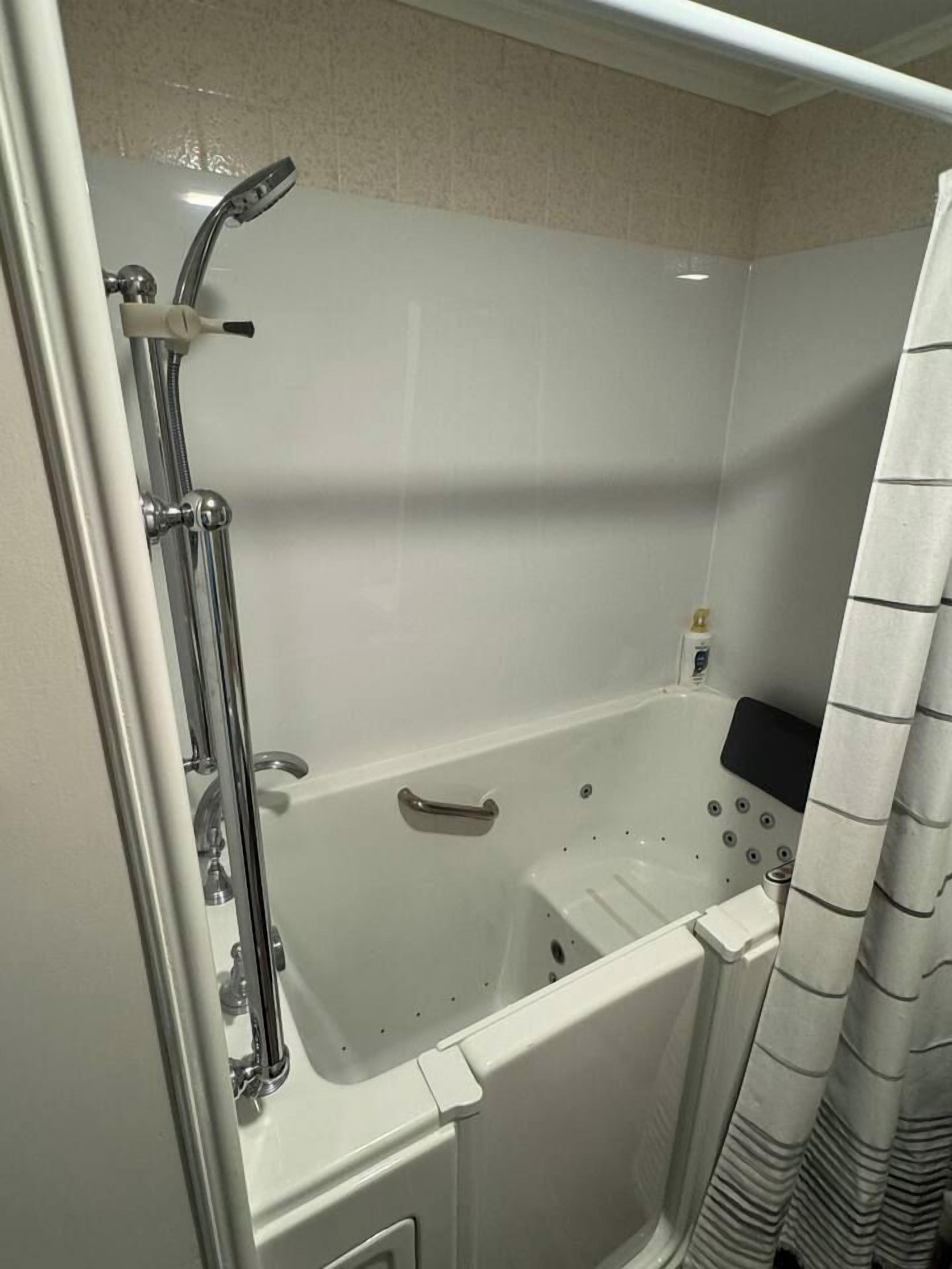 Un baño con bañera, ducha y cortina.