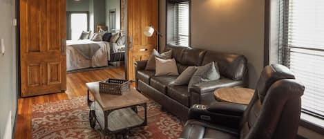A cozy living room with a leather sofa, a coffee table, and a patterned rug.