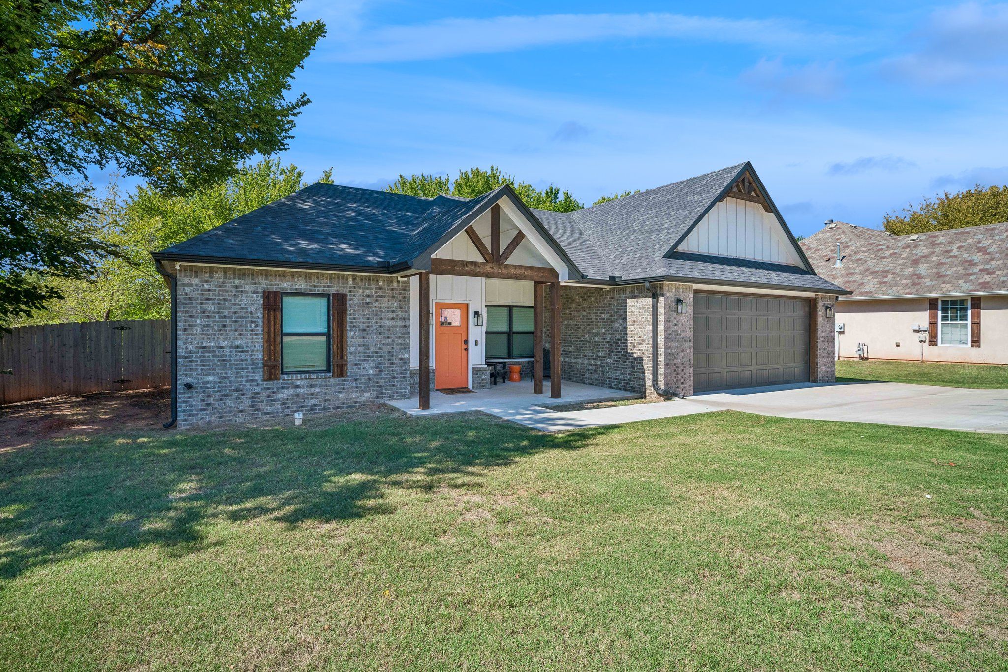A single-story house with a garage, a front porch, and a well-maintained lawn.