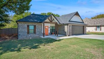 A single-story house with a garage, a front porch, and a well-maintained lawn.