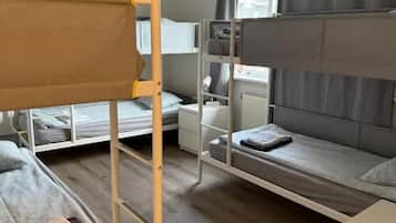 Una camera del dormitorio con letti a castello, una scrivania, una sedia e una finestra con tende.