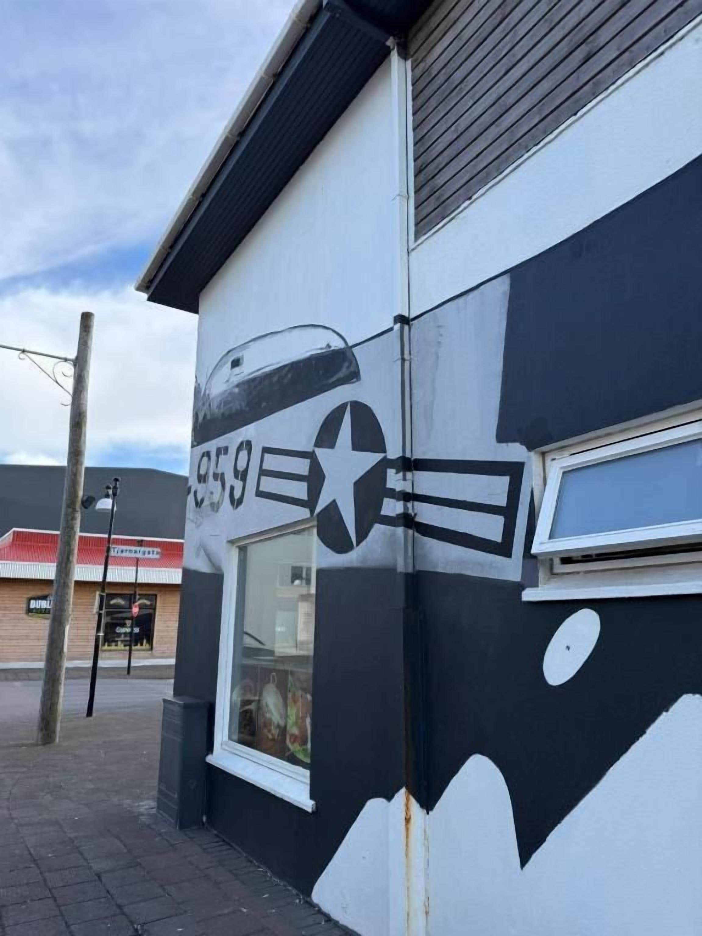 Un edificio con un murale bianco e nero raffigurante una stella e un aereo.