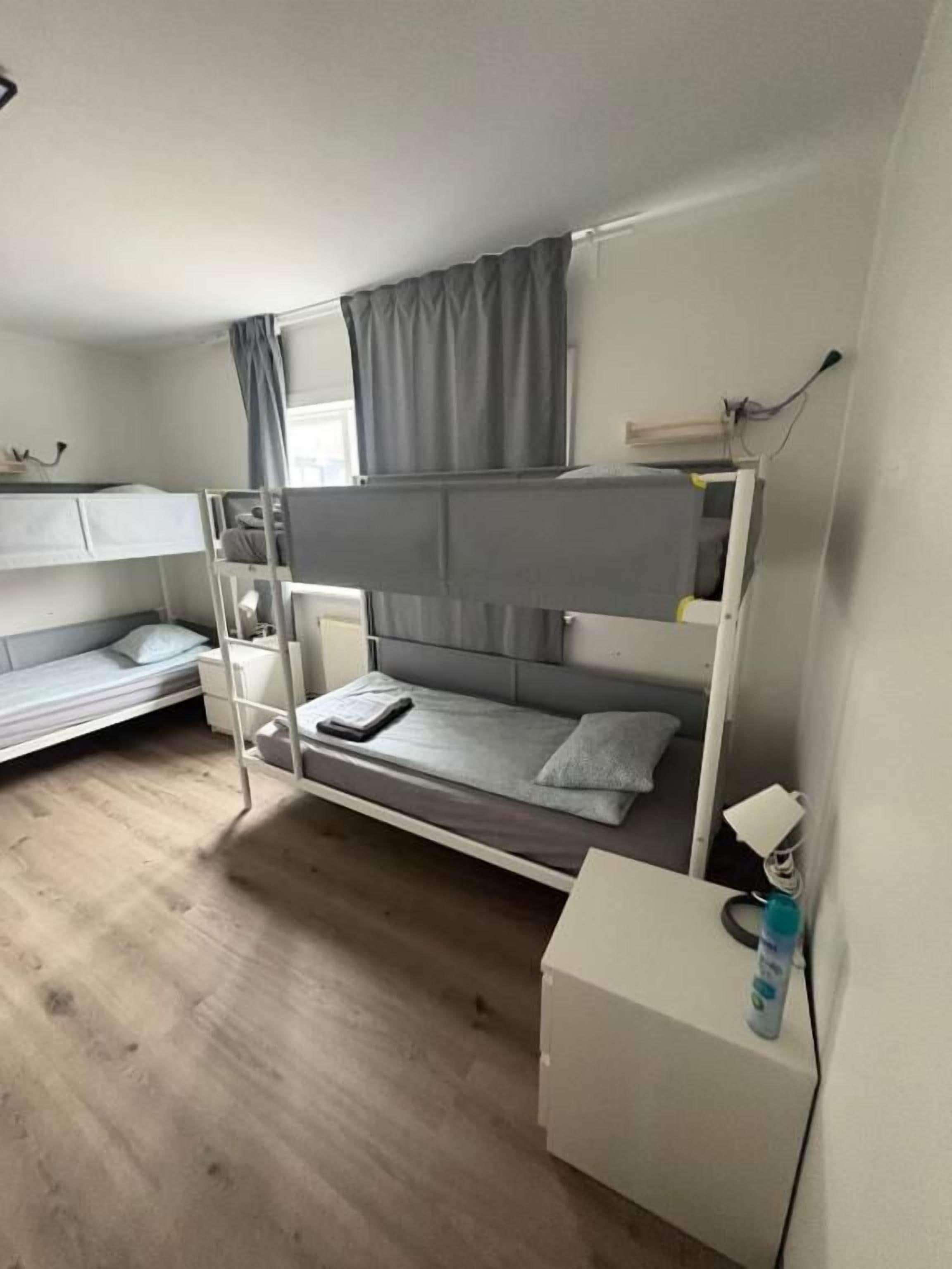 Quarto com beliche, escrivaninha e janela.