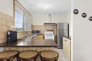 A kitchen with a central island, a microwave, a stove, and a refrigerator. - The Moorings Tides & Tails - Pets Welcome! (St Leonards)