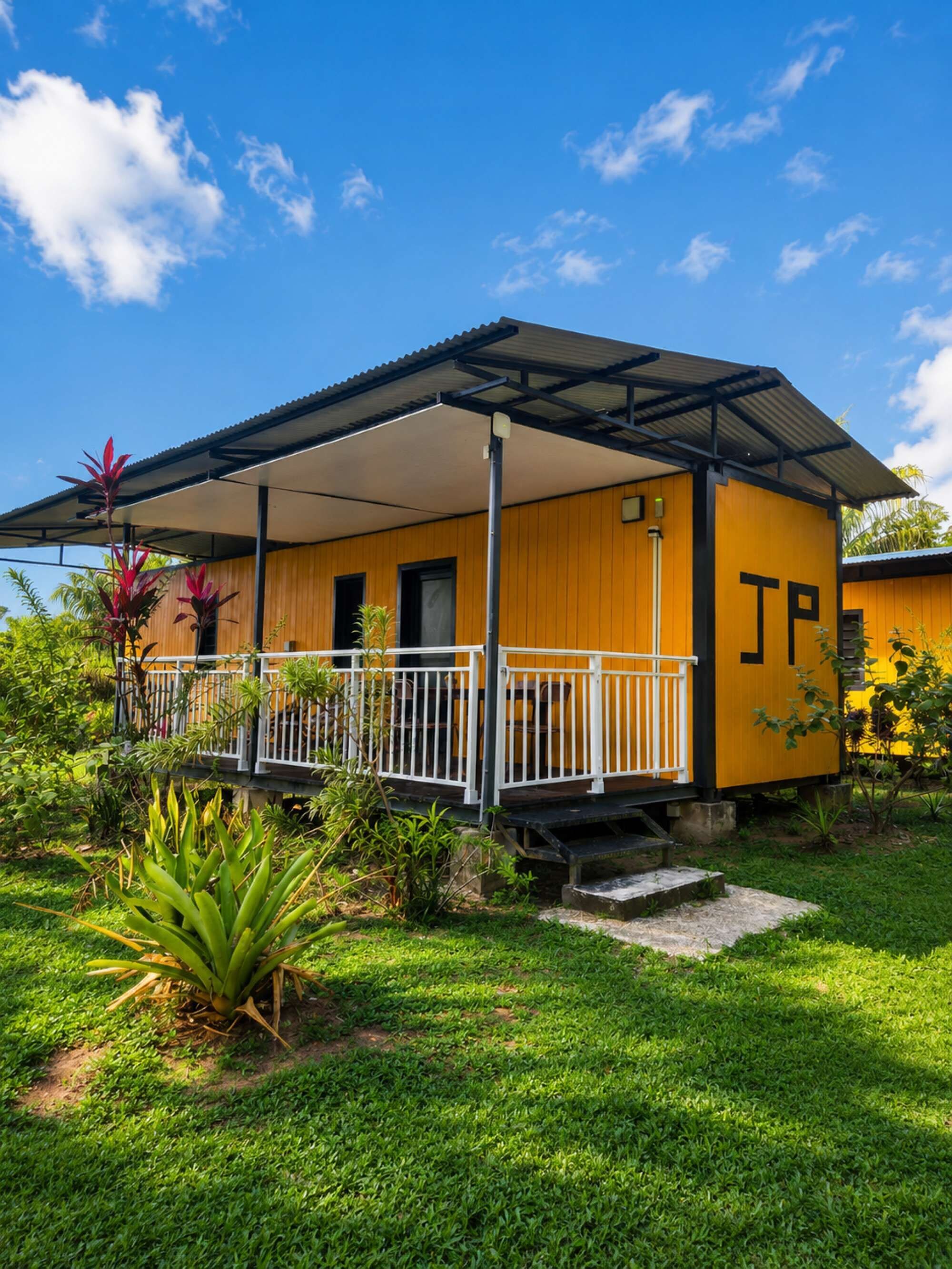 A yellow building with a covered porch and a 'JP' sign.