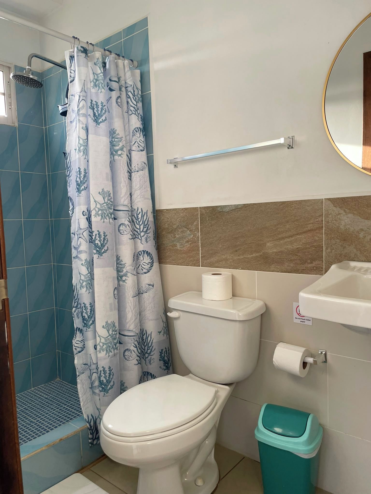 A bathroom with a shower, toilet, and sink.