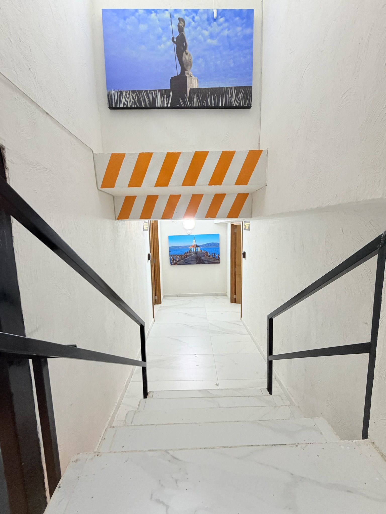 A staircase with a view of a coastal scene at the top.