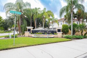 A street sign for Coral Castle St. in front of a building with a sign that reads 'Fiesta Xod.' - Elegant 3BR Home | Gated Community | Shared Amenities & Pool (Kissimmee)