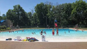 A swimming pool with people in the water, surrounded by trees. - Suite Victory #7 On Main St w/Reserved Parking (Galena)