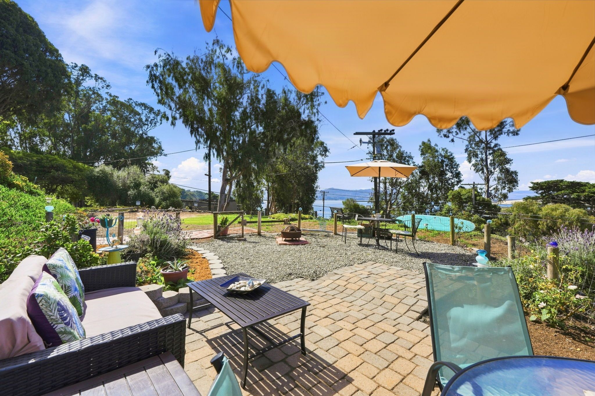 Un espace extérieur aménagé en terrasse, avec des sièges, une table et des parasols.