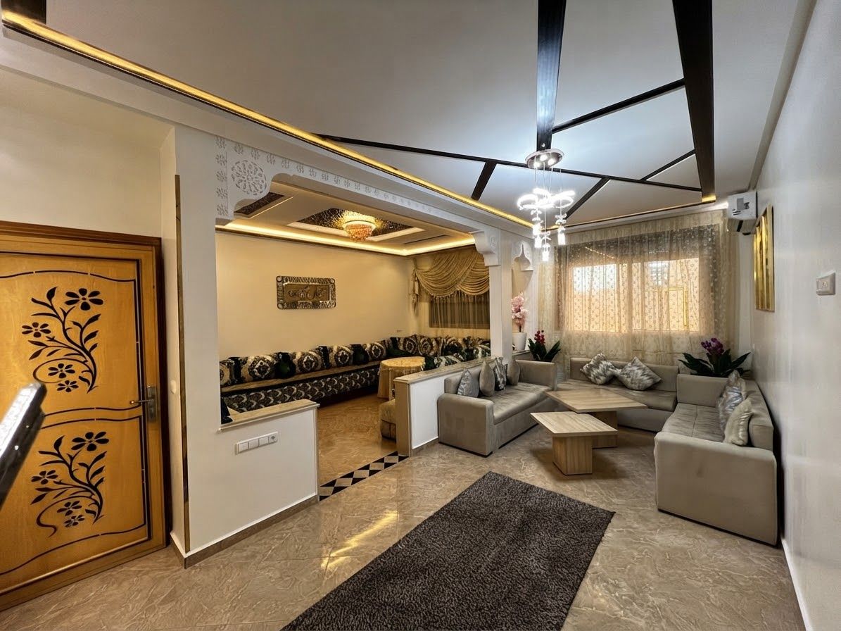 Een moderne woonkamer met een zithoek, een salontafel en een gekleurd tapijt.