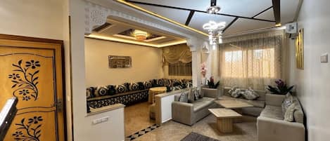 Un salon moderne avec un ensemble de canapés, une table basse et un tapis à motifs.