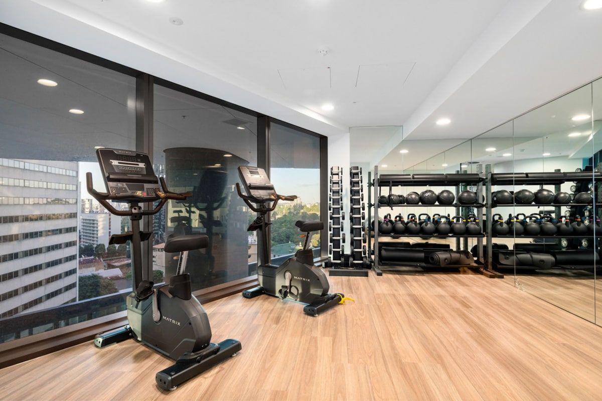 Ein modernes Fitnessstudio mit Cardiogeräten, Kraftstationen und Kettlebells.