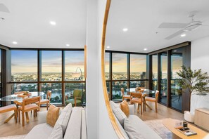 Un intérieur moderne comprenant un coin repas, des sièges et une vue sur le paysage urbain.