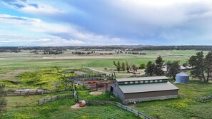 Un paysage rural avec une zone délimitée par une clôture, une grange et une tour à grain.