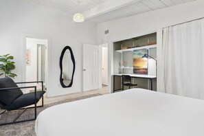 A hotel room with a large bed, a desk with a computer, a chair, a mirror, and a painting on the wall. - Modern Spacious Baja w/ Hot Tub near SDSU, Downtown San Diego, Navy (San Diego)