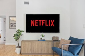 A living room with a television mounted on the wall displaying the Netflix logo. - Modern Spacious Baja w/ Hot Tub near SDSU, Downtown San Diego, Navy (San Diego)