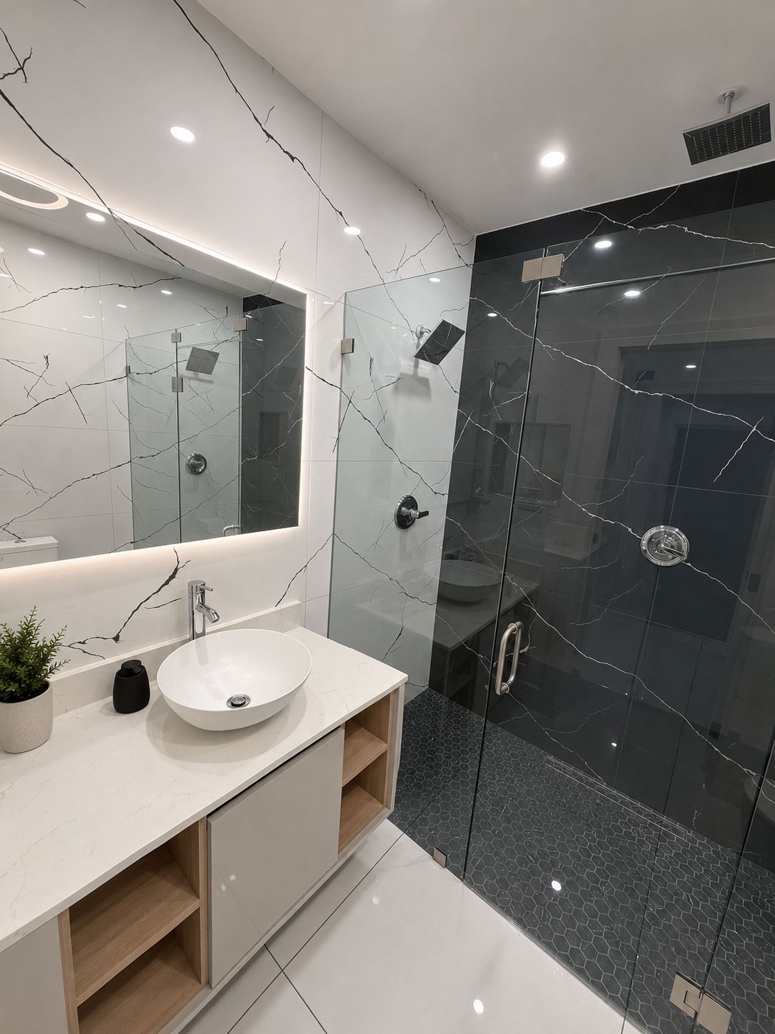 Un baño moderno con tocador de mármol blanco, un espejo grande y cabina de ducha con mampara de vidrio.