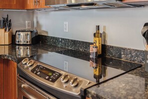 A kitchen with a stainless steel oven, a toaster, and a bottle of olive oil on the counter. - Sojourn 3BD2BA with Balcony, 3 Pools, Beach Access (Virginia Beach)
