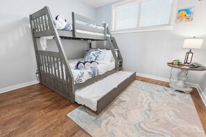 A bunk bed with a ladder, a bedside table with a lamp, and a patterned rug. - Sojourn 3BD2BA with Balcony, 3 Pools, Beach Access (Virginia Beach)