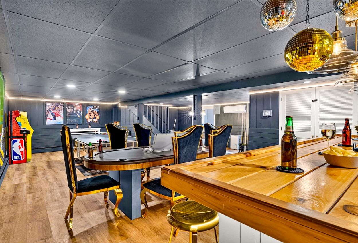 Un espace repas avec une table en bois, des chaises à revêtement noir et un éclairage de type boule à facettes.