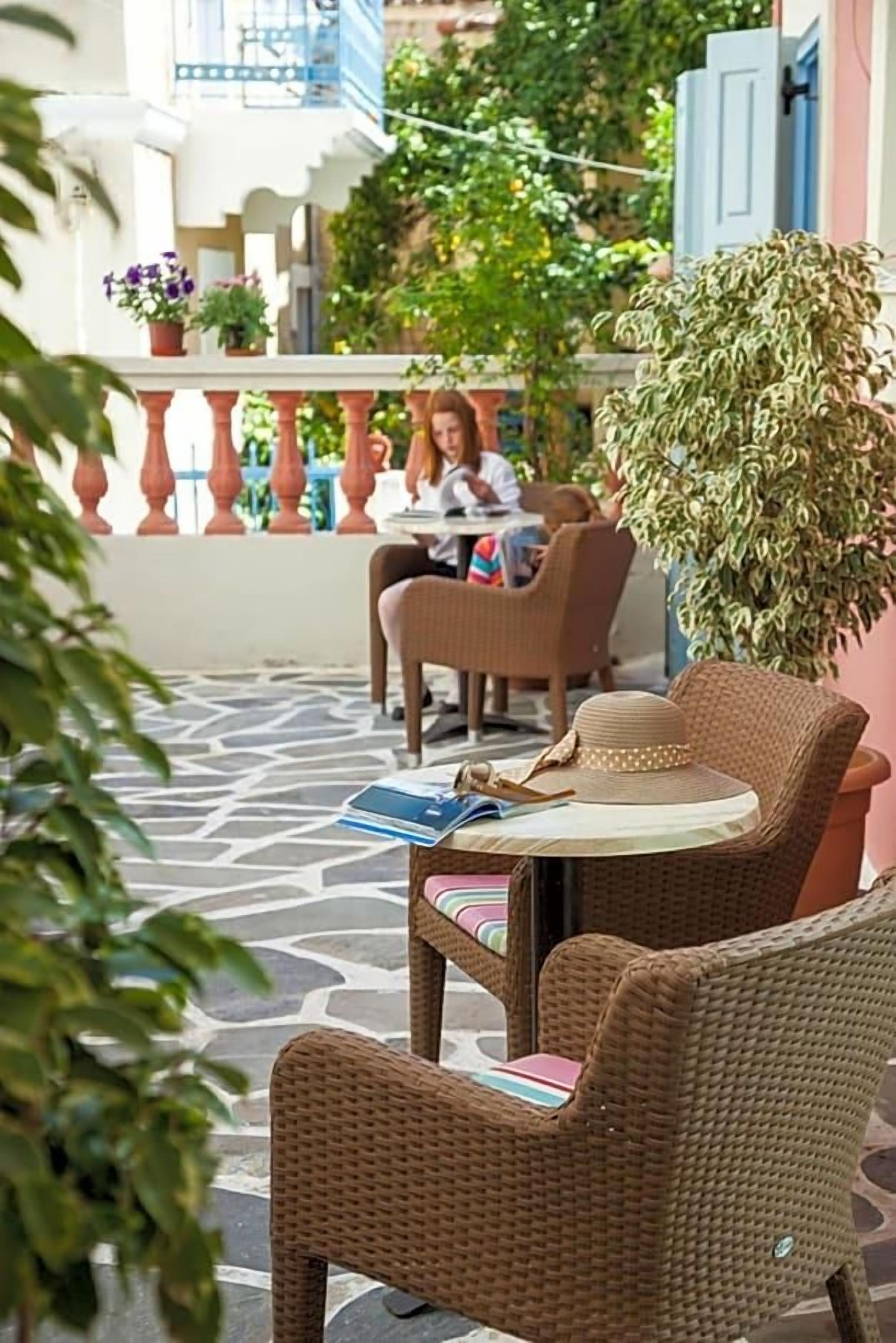 Ein Außenbereich mit Korbmöbeln, einem Tisch mit Hut und einem Blumentopf.