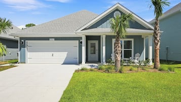 Una casa residenziale con garage, veranda e prato curato.