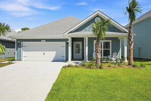 A residential house with a garage, a front porch, and a well-maintained lawn. - Vermilion Cove: Windmark beach, pool, bikes & more (Port St. Joe)
