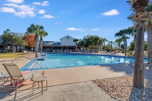 A swimming pool with lounge chairs and a building in the background. - Vermilion Cove: Windmark beach, pool, bikes & more (Port St. Joe)