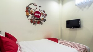 A hotel room with a bed, pillows, a TV, and a wall decoration. - Harmony Beach (Nessebar)